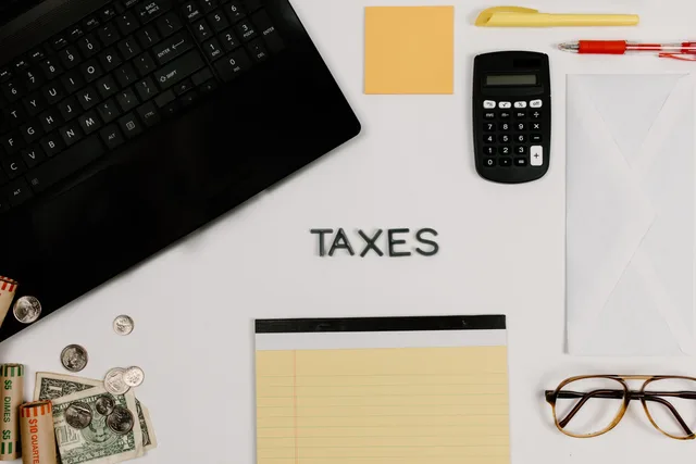 Organized office supplies for managing taxes, featuring a calculator, keyboard, and notepad. How we assess evidence for creator taxes
