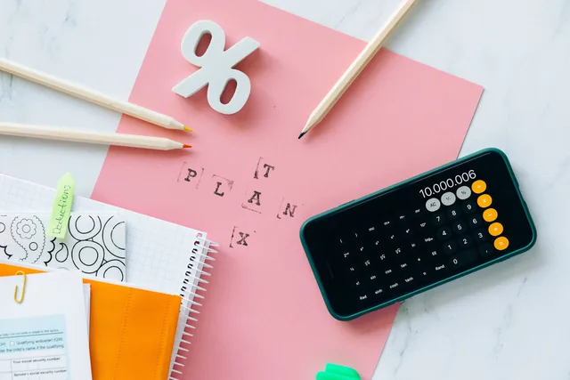 Flat lay showing tax planning tools including a calculator, pencils, and stationery items. How to set creator tax service standards without weekly chasing