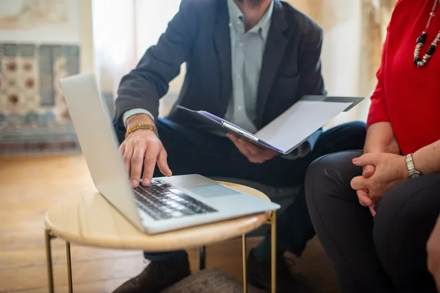 Professional meeting with a laptop and documents in an office setting. Creator tax vendor due diligence checklist