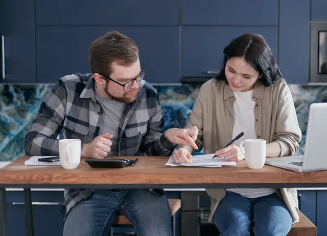 Mid adult couple reviewing bills and managing finances at home. Brand deals: UK creator tax reporting explained