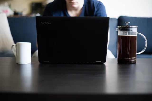 Coffee table as a desk - working from home with a coffee and a laptop. Produced by Microbizmag.co.uk and made available under Creative Commons. Feel free to use in your own content with attribution in the form of a link to www.microbizmag.co.uk. How to register as self-employed for your influencer income